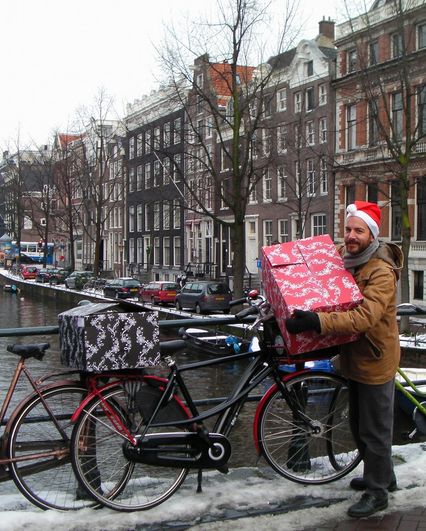 Alix porte des gros paquets de cadeau sur son vélo drooderfiets