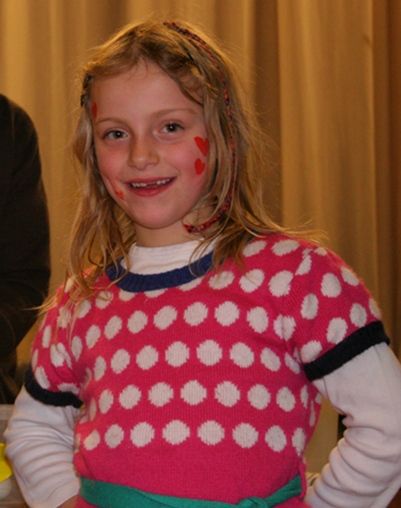 une fille souris avec des coeurs sur les joues