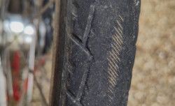 détail de pneu lisse laissant apparaitre des traits jaunes