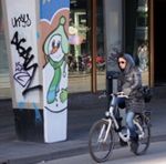 Une jeune fille à vélo devant un bonhomme de neige
