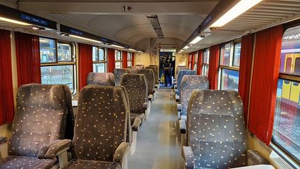 Photo intérieur d'un wagon avec des rangées de 3 fauteuils gris