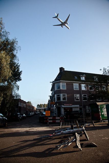 (avion qui vole bas au dessus d'un croisement où le vent a renversé les panneaux